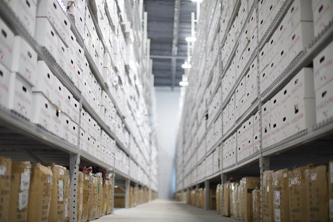 Shelves of inventory in boxes stack high in warehouse
