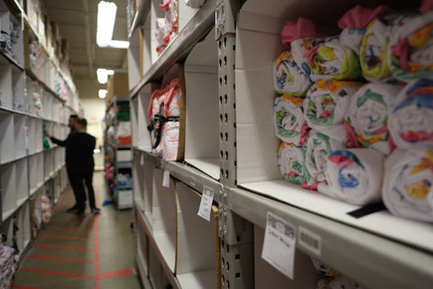 Minky Couture Warehouse bins with employees in background