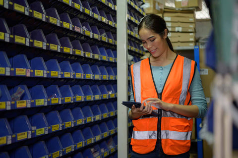 female warehouse worker using ipad for inventory checks