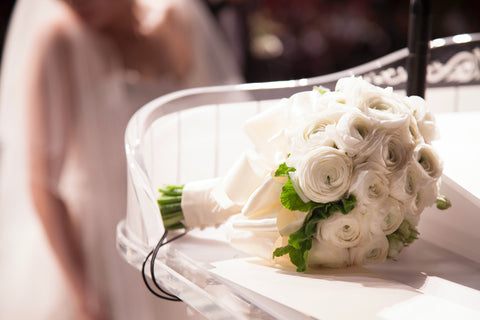 wedding bouquet on a table with bride in the background