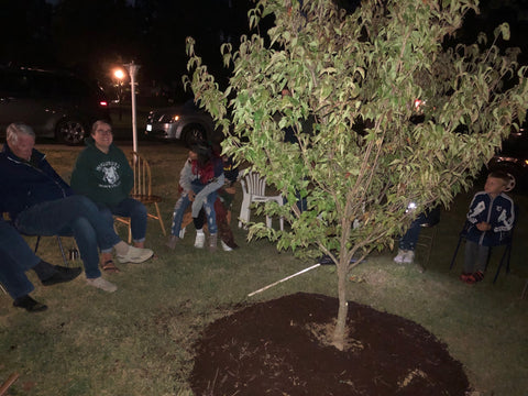 Family gathered around tree memorial, planted with human cremains mixed with Let Your Love Grow.