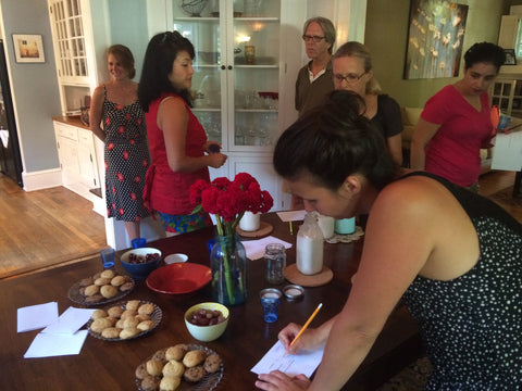 People gathered around a table tasting and review nutmilk samples