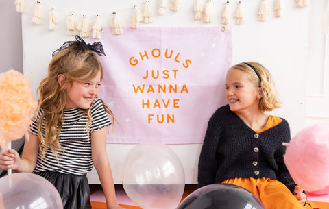 pink canvas banner that says "ghouls just wanna have fun"