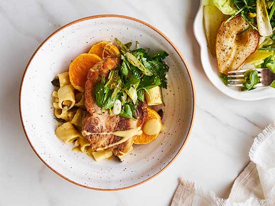 Échine de porc confite à l'oignon doux accompagnée de rigatoni et d'une courge fondante. Une recette servie lors du Gala DUX Manger Mieux