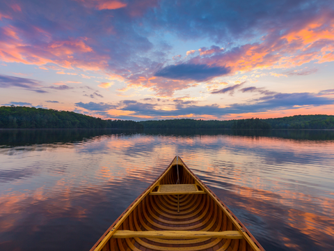 Canoe on lake at sunset