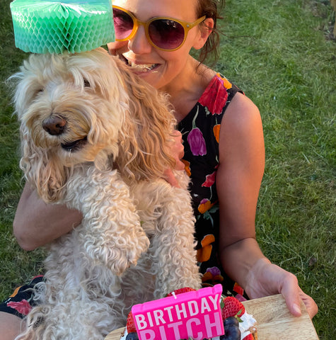 woman holding dog and birthday cake