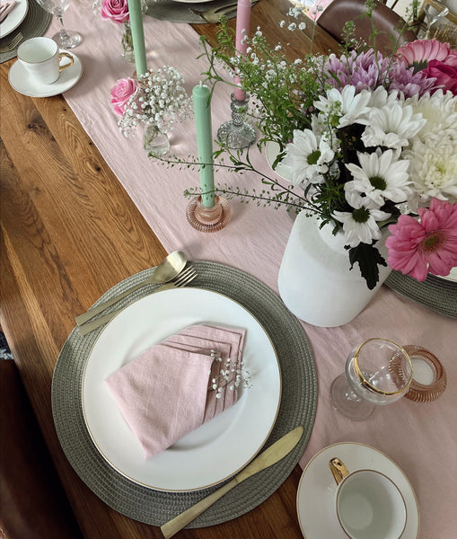 A pastel dinner table lay out with vintage plates