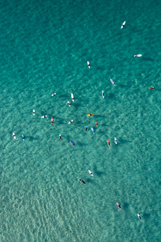 Top-down photo of surfers in clear water