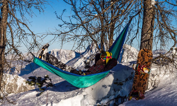 A man enjoying his travel hammock in the snow