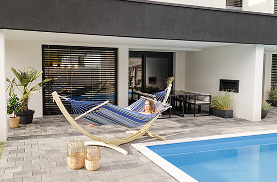 A woman sat in her hammock and stand by the pool