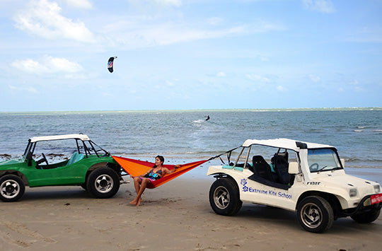 Travel Hammock attacked to two cars by the sea