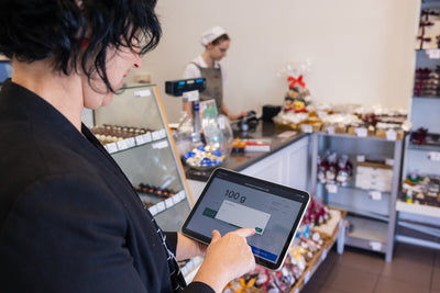 Woman on ipad using Shopify POS System Selecting Counter Chocolate by Gram