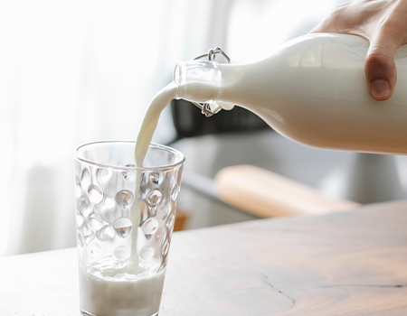 Pouring milk in a glass from a bottle