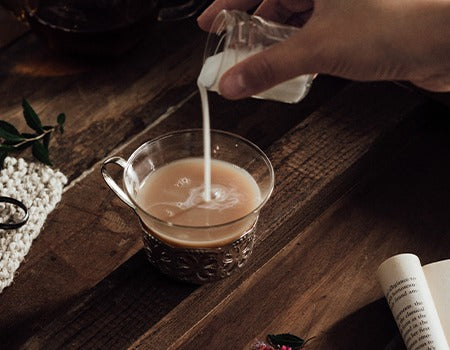 Adding milk to a spoonful of coffee