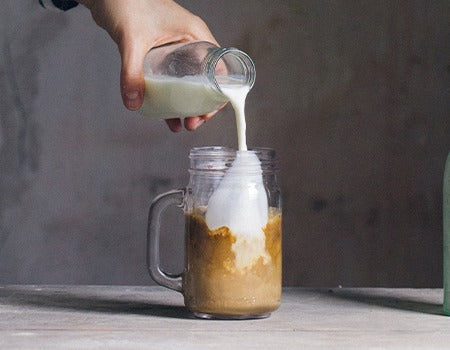 Adding the coffee mixture into a glass filled with ice