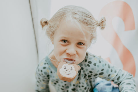 Little girl using Mattie the Monkey AutoBrush for Kids brush