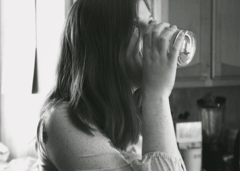 Black and white image of a girl drinking a glass of water, for AutoBrush