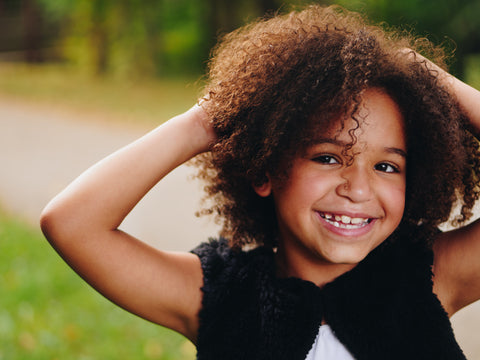 Smiling girl with curly hair posing