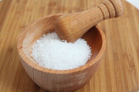 Salt in a wooden mortar with the pestle on top, for AutoBrush