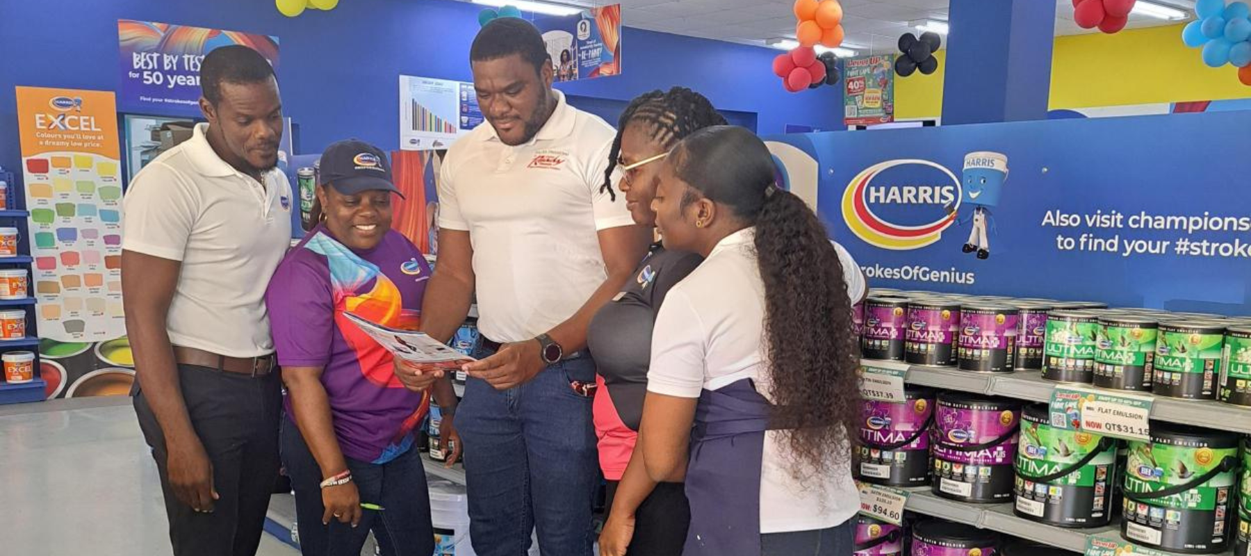 Shamar Shorey, Business Development Officer, Unicomer Barbados Ltd reviews financing details with the store team in Barbados.