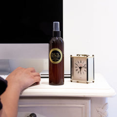 Essential Oil Room Spray on Home Office Desk with a computer and clock