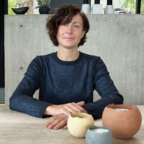 Karen Konzuk sits at table with Orbis Terra vessels in the forefront.