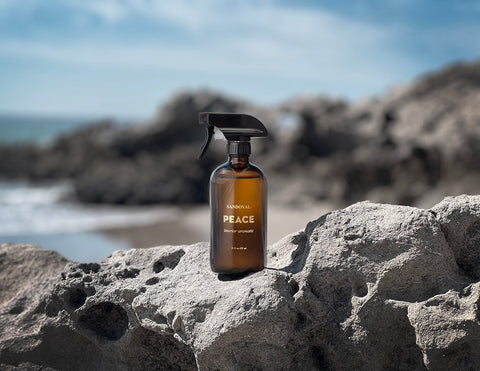 peace interior aromatic mist in amber bottle on leo carillo Malibu beach