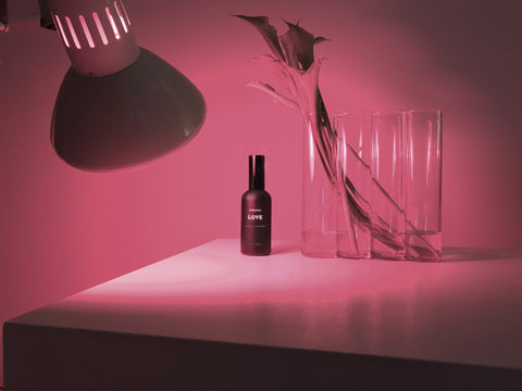 love aromatic coecntrate mist in black bottle under red light lamp