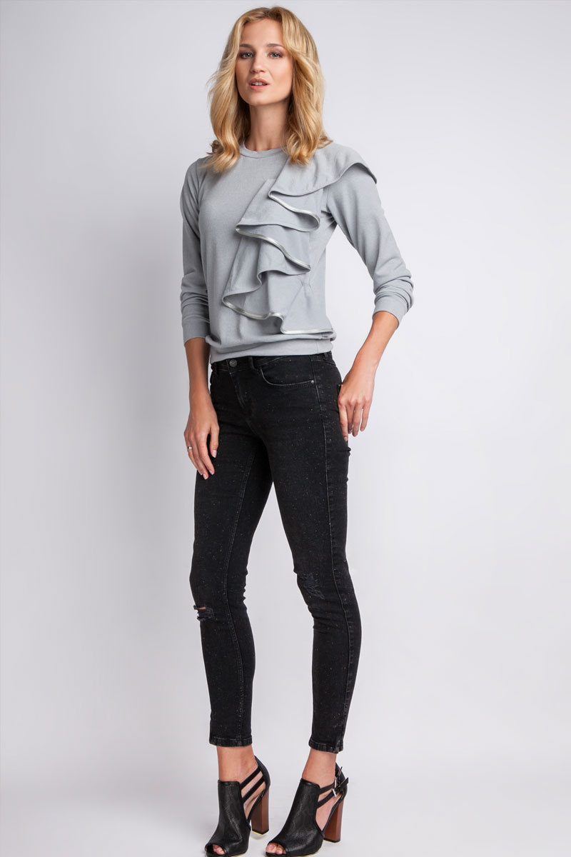 Pull en maille fine gris, avec volants sur le buste.