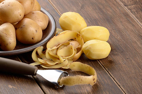 Potato peelings on wooden table