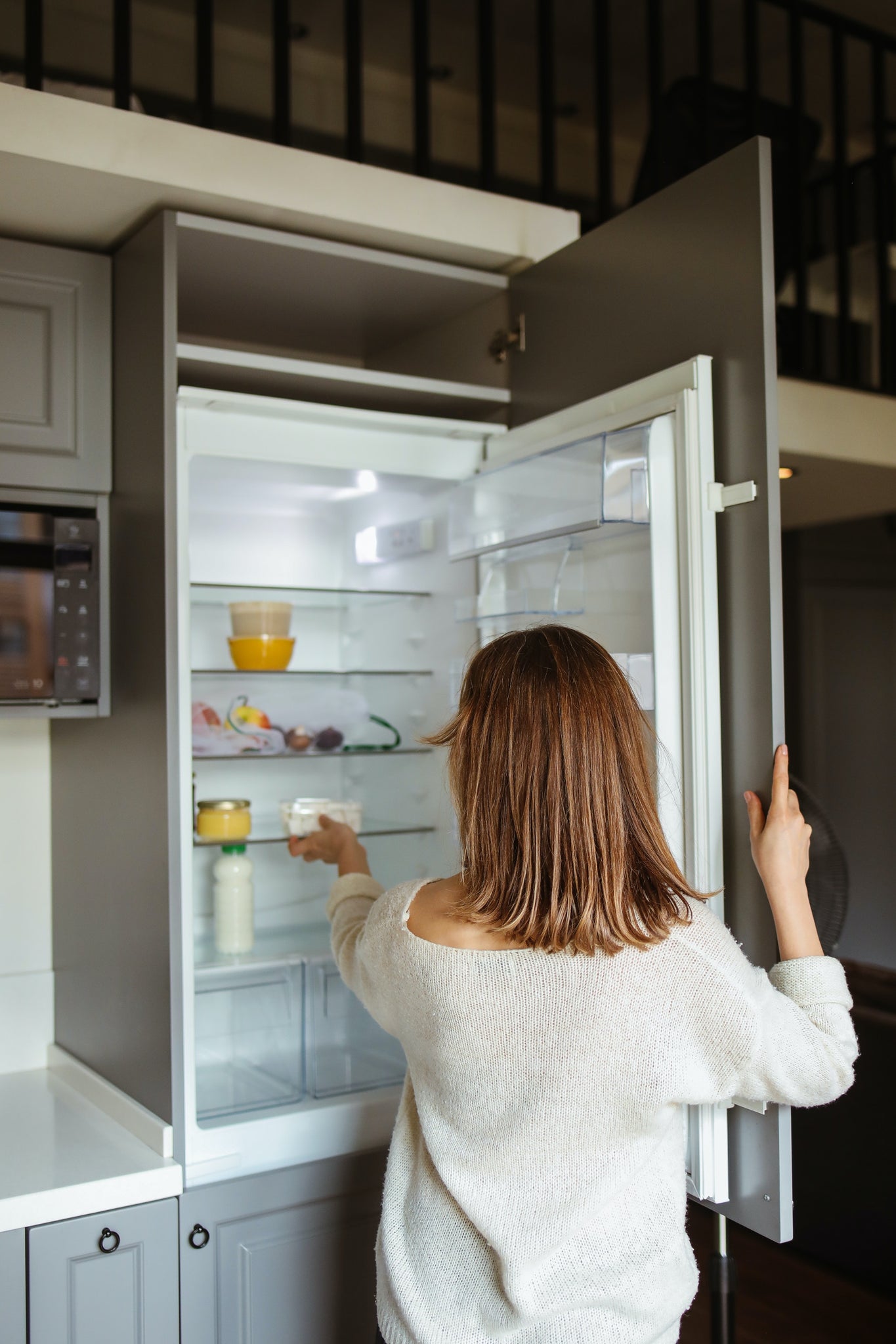 Woman putting food in fridge