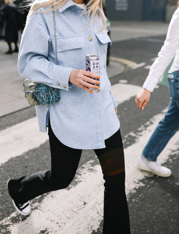 Woman walking with can of DASH Water