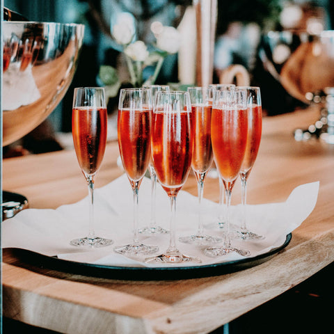 Champagne flutes on a tray with red mocktail