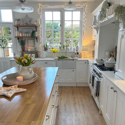 Large window in kitchen with pom pom lights around the edge