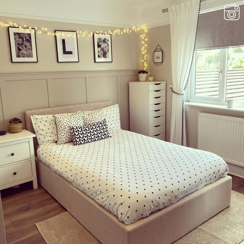 Pom pom fairy lights along a bedroom wall