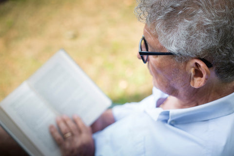 man sitting in chair in garden reading