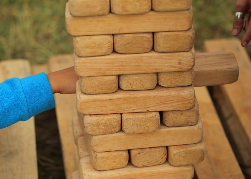 two people playing outdoor jenga in garden