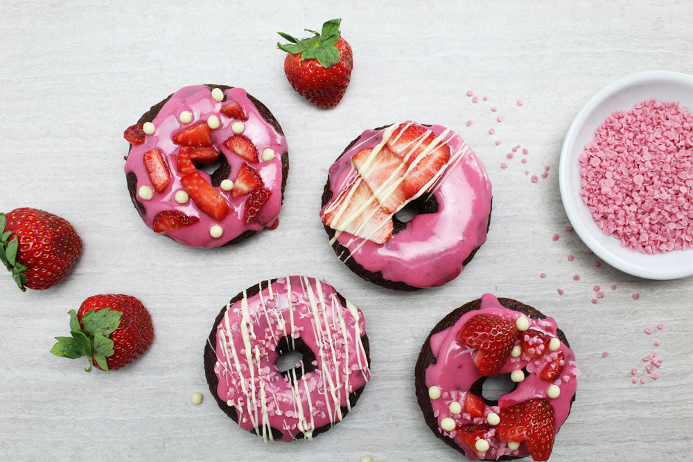 Strawberry chocolate Cake Donut with white chocolate drizzle, fresh strawberries, and white crispearls