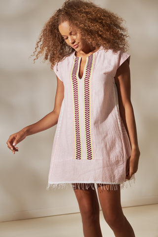 woman wearing a pink caftan with two stripes in the middle in Tibeb pattern