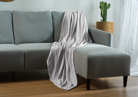 grey muslin blanket on couch