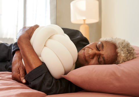lady sleeping with throw pillow in hotel