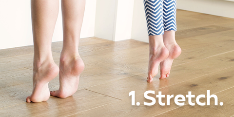 Two sets of feet stretching with toes on ground and heels lifted