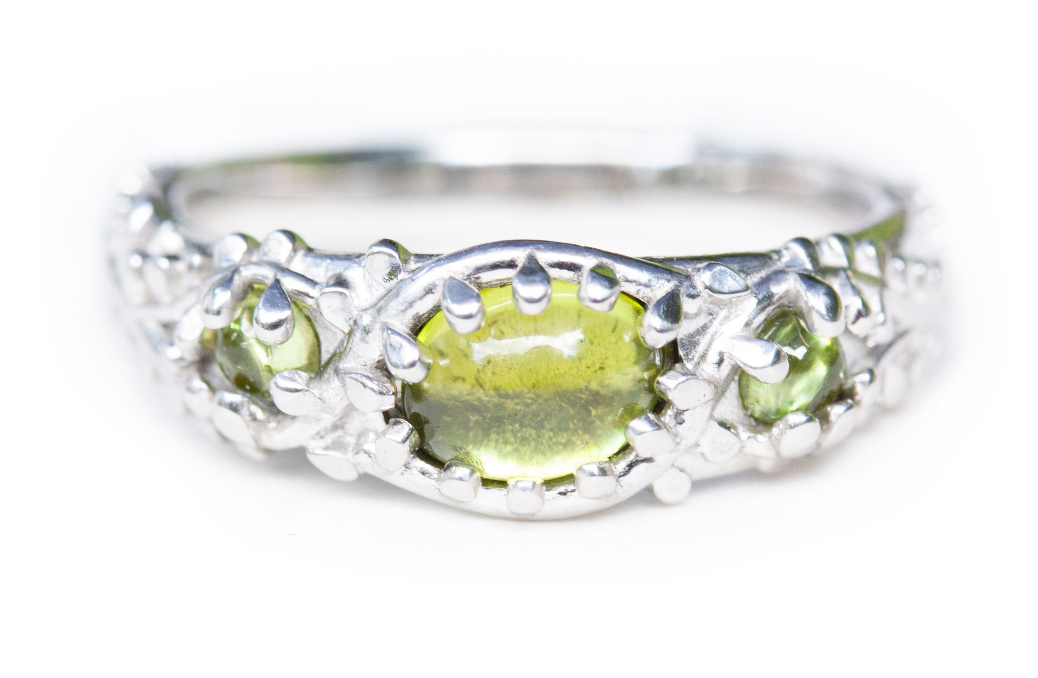 Oval Cabochon Peridot in platinum ring with mossy vine texture