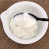 Creamy body oil in a bowl stirred by black metal spoon