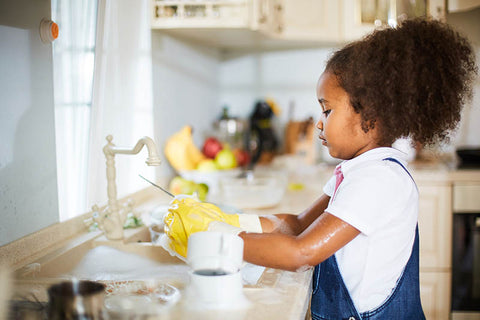 Girl washing dishes in the kitchen