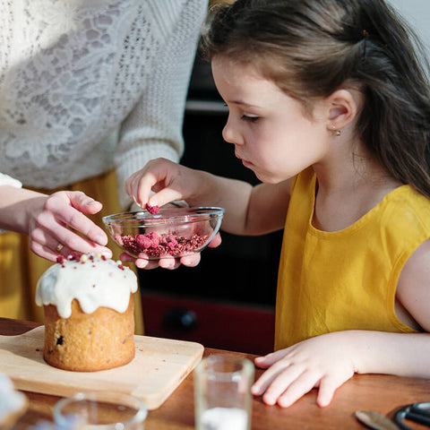 Child at the kitchen counter standing on a toddler tower