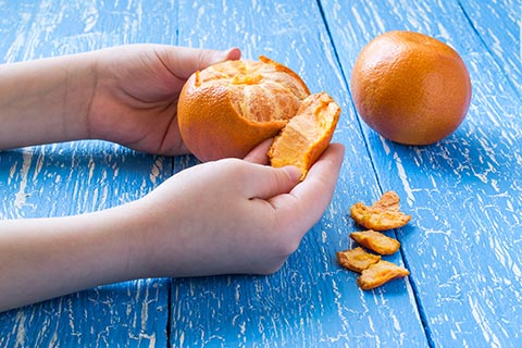 Kid peeling an orange