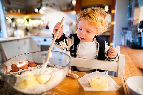 Kid making pancakes on learning tower