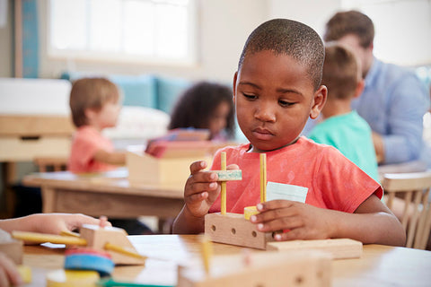 Boy playing with Montessori wood toys