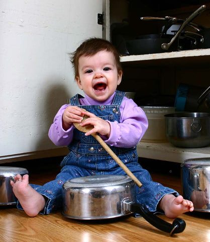 Toddler in kitchen with pots and pans